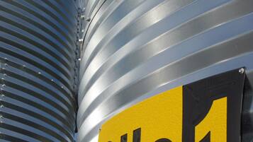 A close-up of a corrugated metal surface with a yellow and black sign reading "Silo 1".