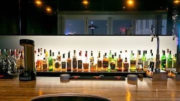 A bar with a variety of liquor bottles and a Guinness beer tap.