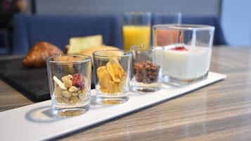 Bandeja de desayuno con diversos alimentos y bebidas sobre una mesa.