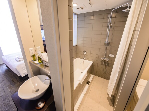 A modern bathroom with a bathtub, shower, and sink. - Shinjuku Granbell Hotel (Tokyo)