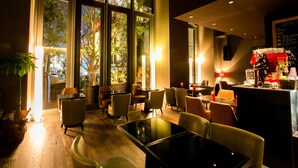 A modern interior with large windows, a bar area, and seating arrangements. - Shinjuku Granbell Hotel (Tokyo)