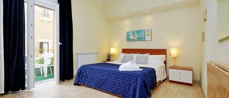 A bedroom with a bed, bedside tables, a painting, and a view through an open door.