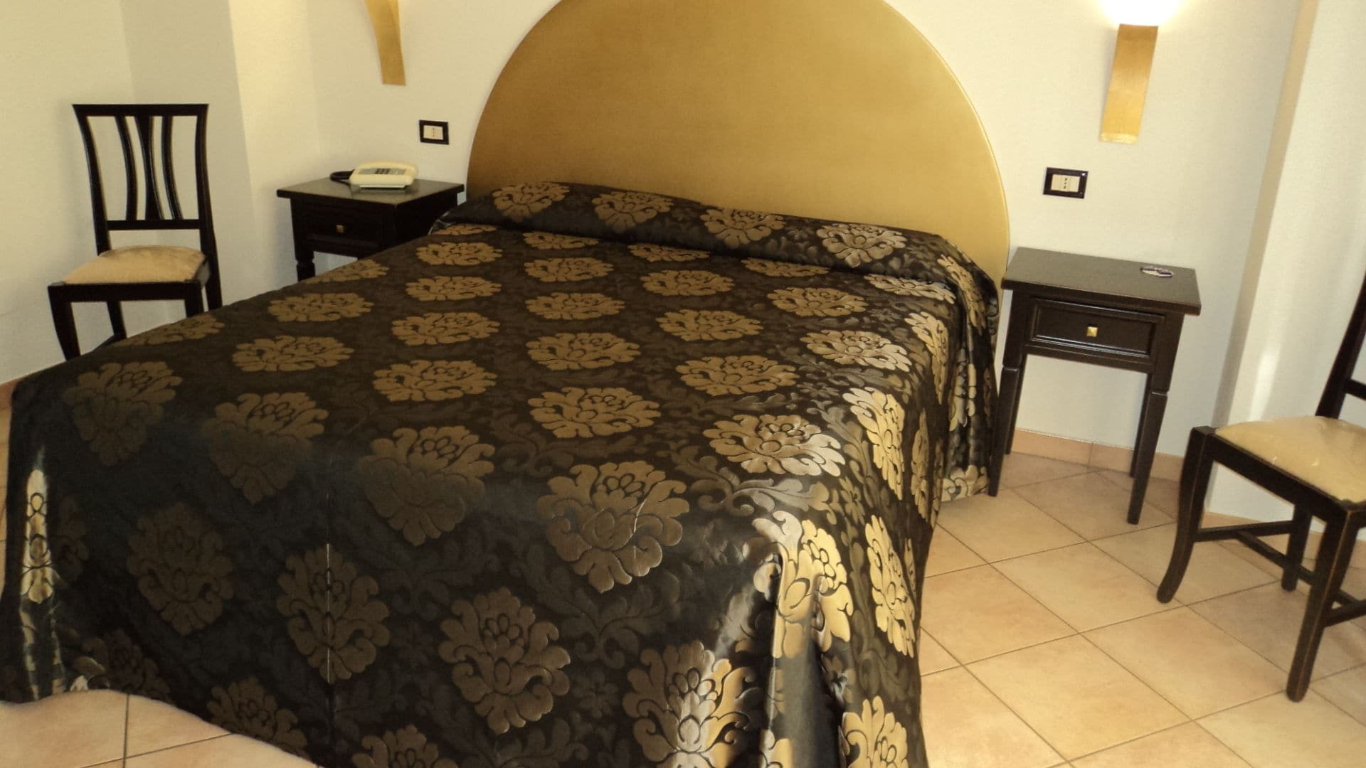 Une chambre à coucher avec un grand lit, une table de chevet, une chaise et un bureau.