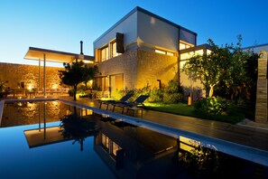 A modern house with a swimming pool, outdoor furniture, and a well-maintained garden. - Conte Marino Villas (Platanias)