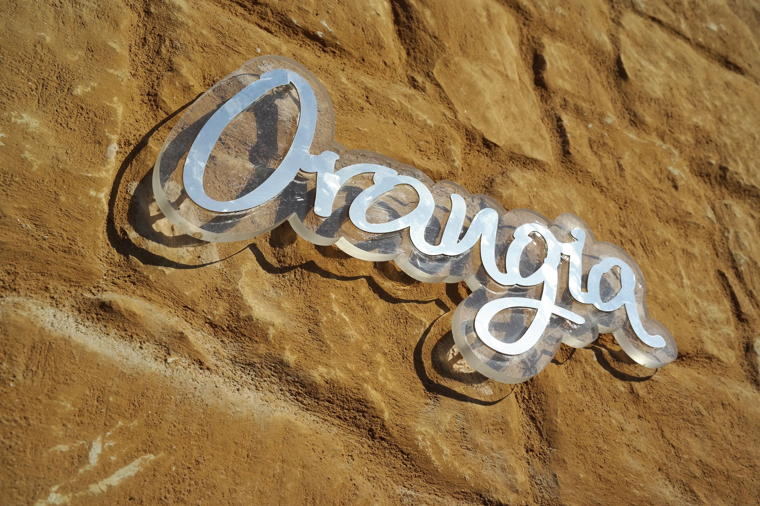 A sign with the word "Orangia" on a textured surface.