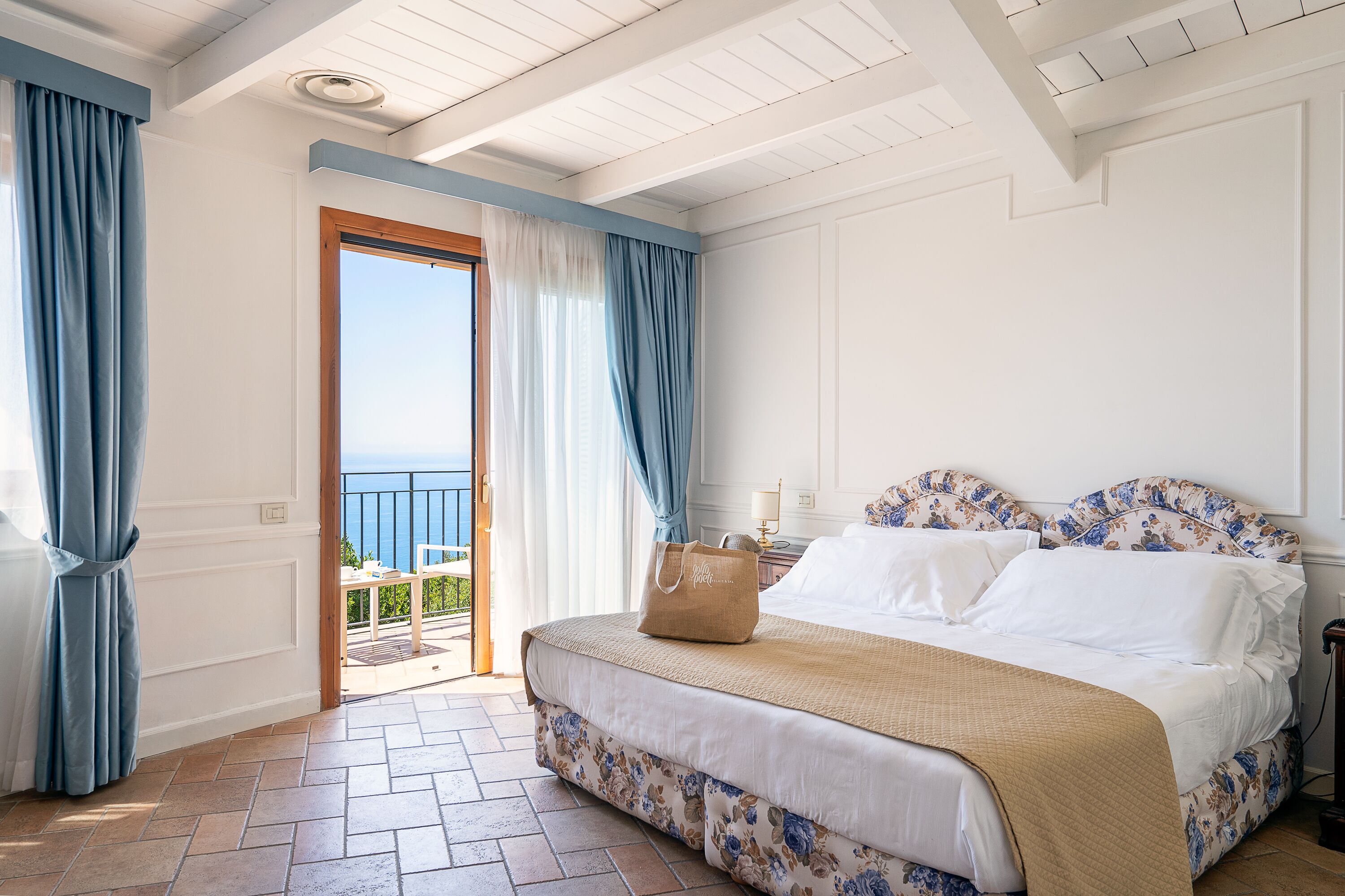 Un dormitorio con cama, maleta y vistas al exterior.