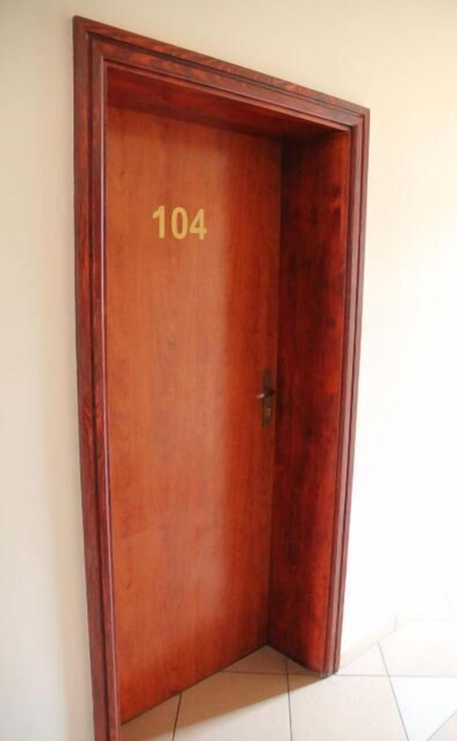 Eine Holztür mit der Nummer 104, die eine Zimmernummer angibt.