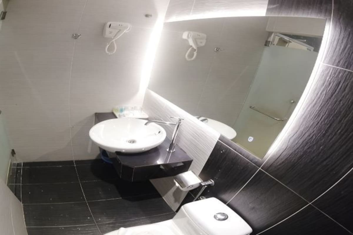 A modern bathroom with a sink, toilet, and shower.