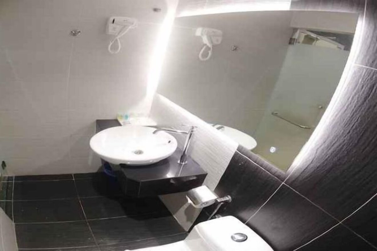 A bathroom with a toilet, sink, and shower.