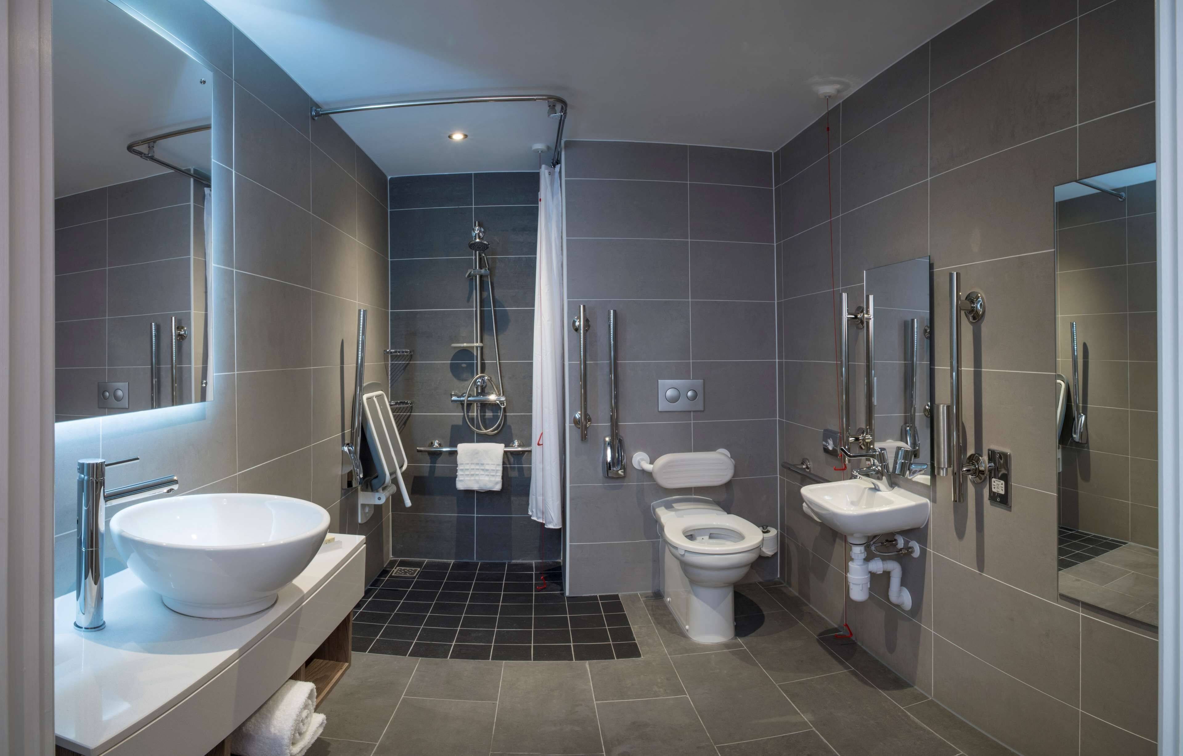 Un baño moderno con un lavamanos grande, inodoro y zona de ducha.