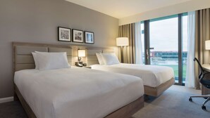 A hotel room with two beds, a large window with a view, and a desk with a chair. - Hilton Garden Inn Manchester Emirates Old Trafford (Manchester)