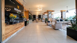 A spacious lobby with a reception desk, seating area, and large windows. - Monarch Hotel (Addis Ababa)