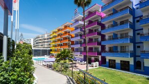 A hotel with colorful balconies, a pool area, and a well-maintained lawn. - Las Gacelas (San Bartolomé de Tirajana)