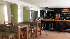 Un espace bar avec des tabourets en bois et un comptoir.