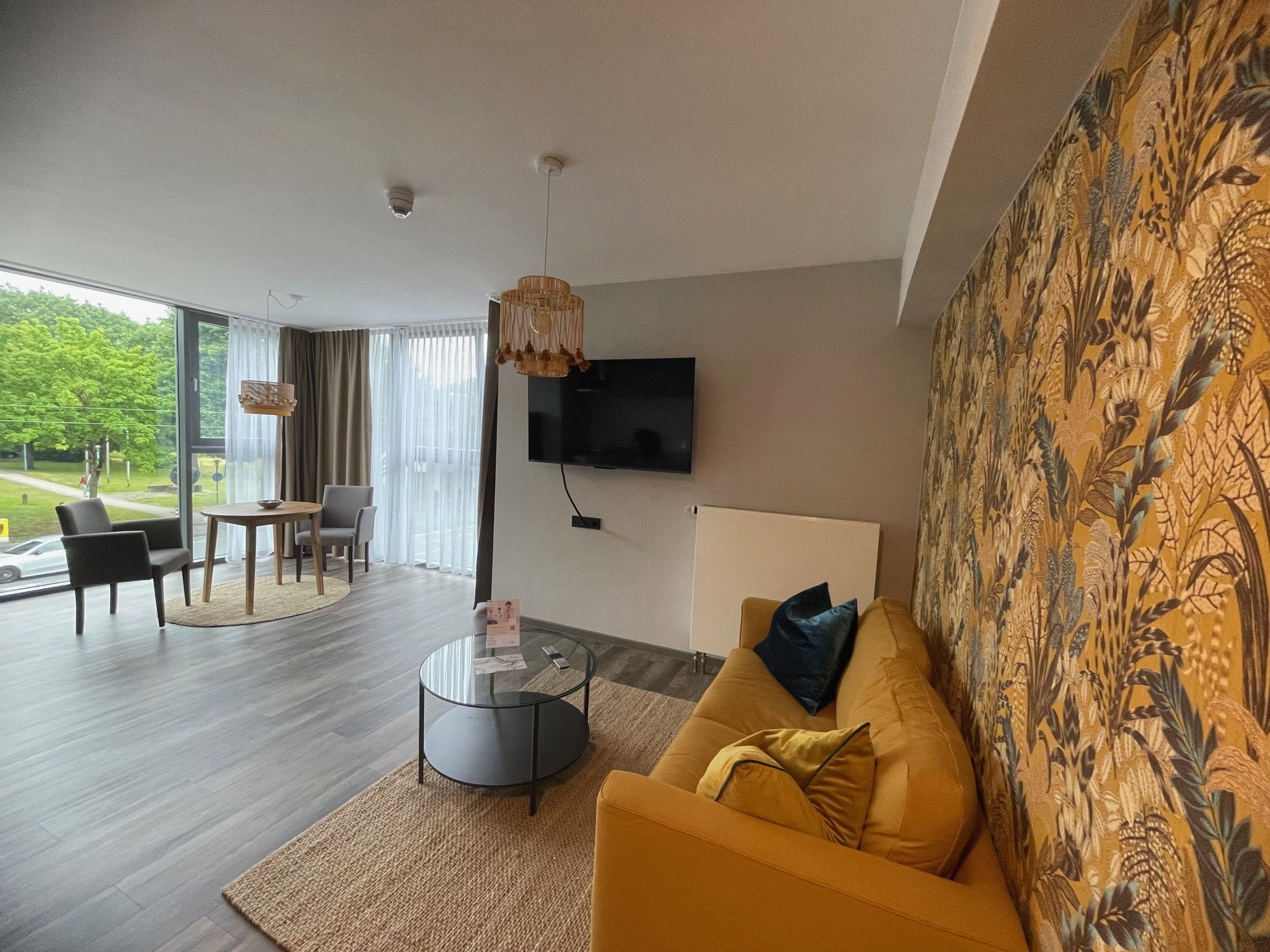 A modern living room with a sofa, a coffee table, and a TV mounted on the wall.
