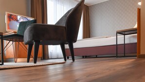A modern hotel room with a bed, a chair, a table, and a TV. - EuroStar Hotel (Castrop-Rauxel)