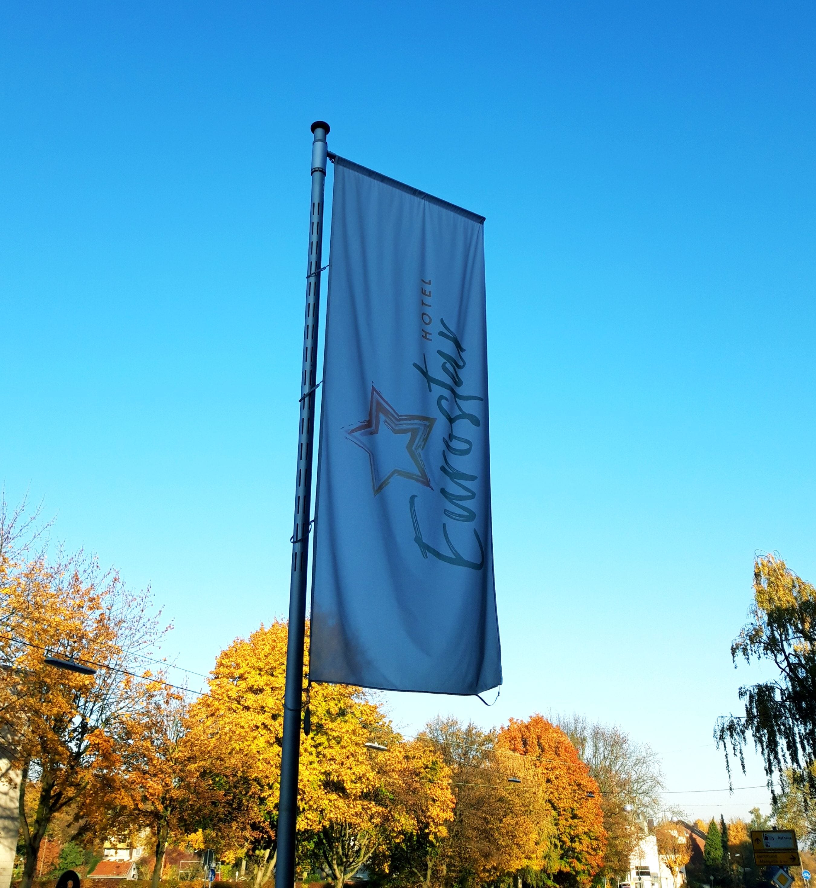 Eine Flagge mit einem Stern und Text, an einem Fahnenmast befestigt.
