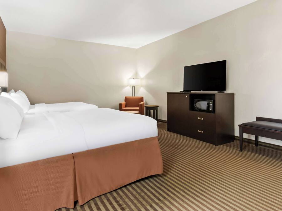 Habitación de hotel con una cama grande, un televisor de pantalla plana, un escritorio y una silla.