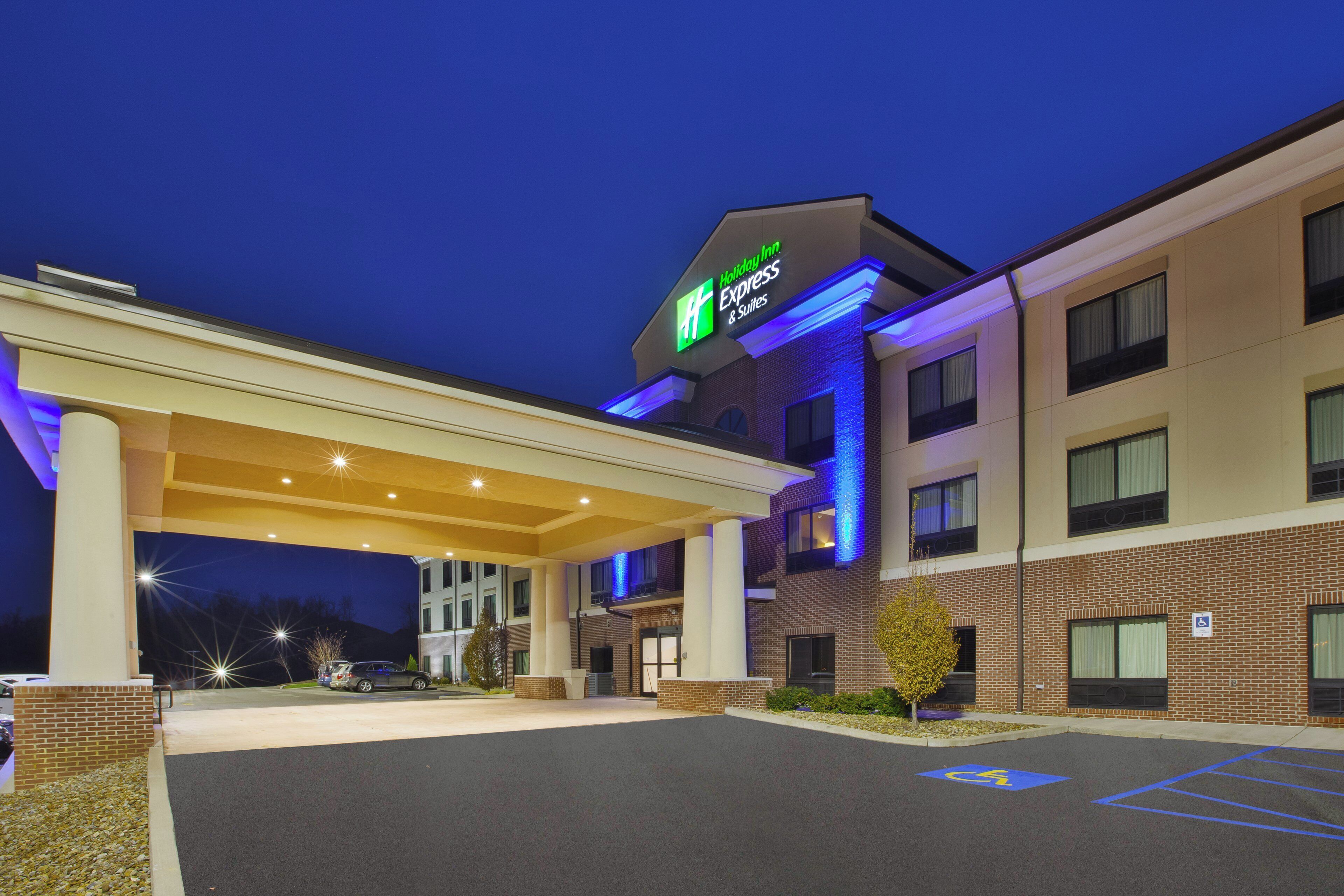 Un Holiday Inn Express & Suites con entrada techada, estacionamiento y fachada de ladrillo.