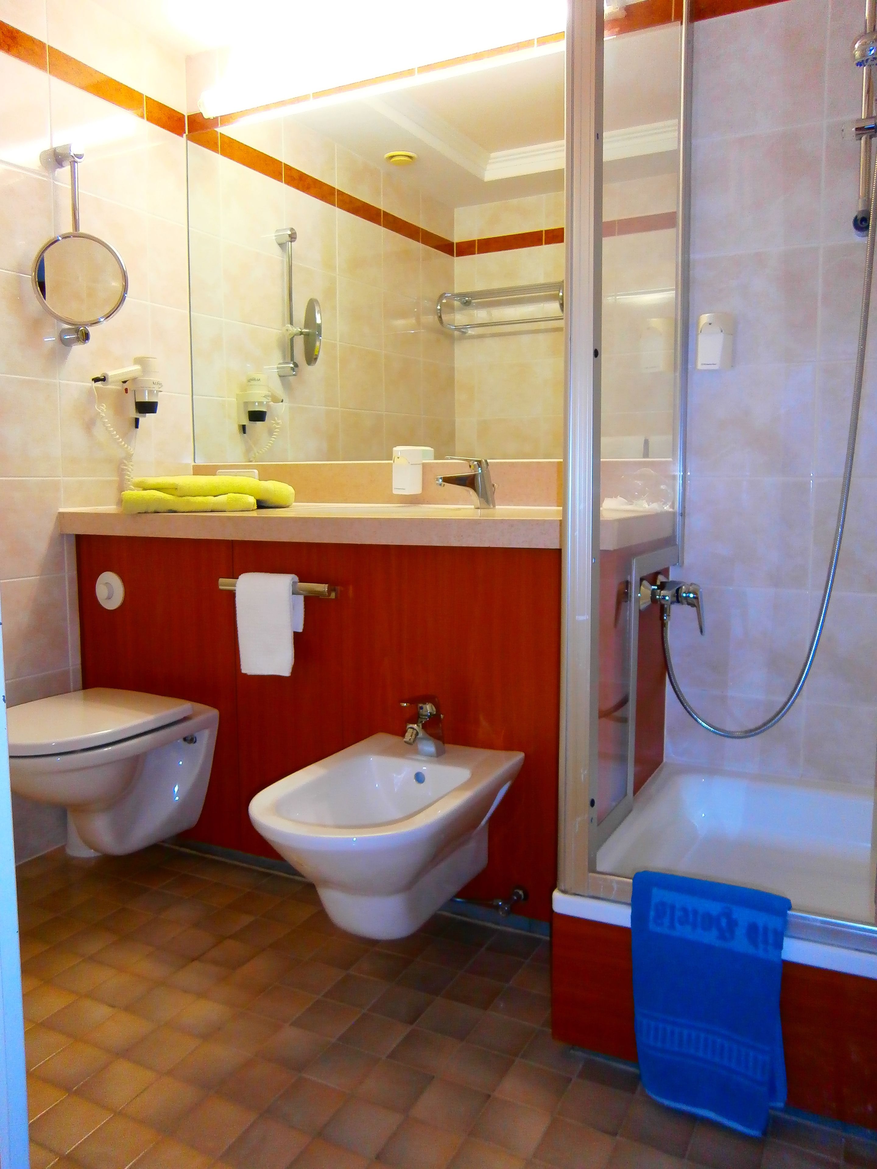 Ein Badezimmer mit Toilette, Bidet, Waschbecken und Dusche.