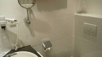 Baño con lavamanos, inodoro y toallero con dos toallas.