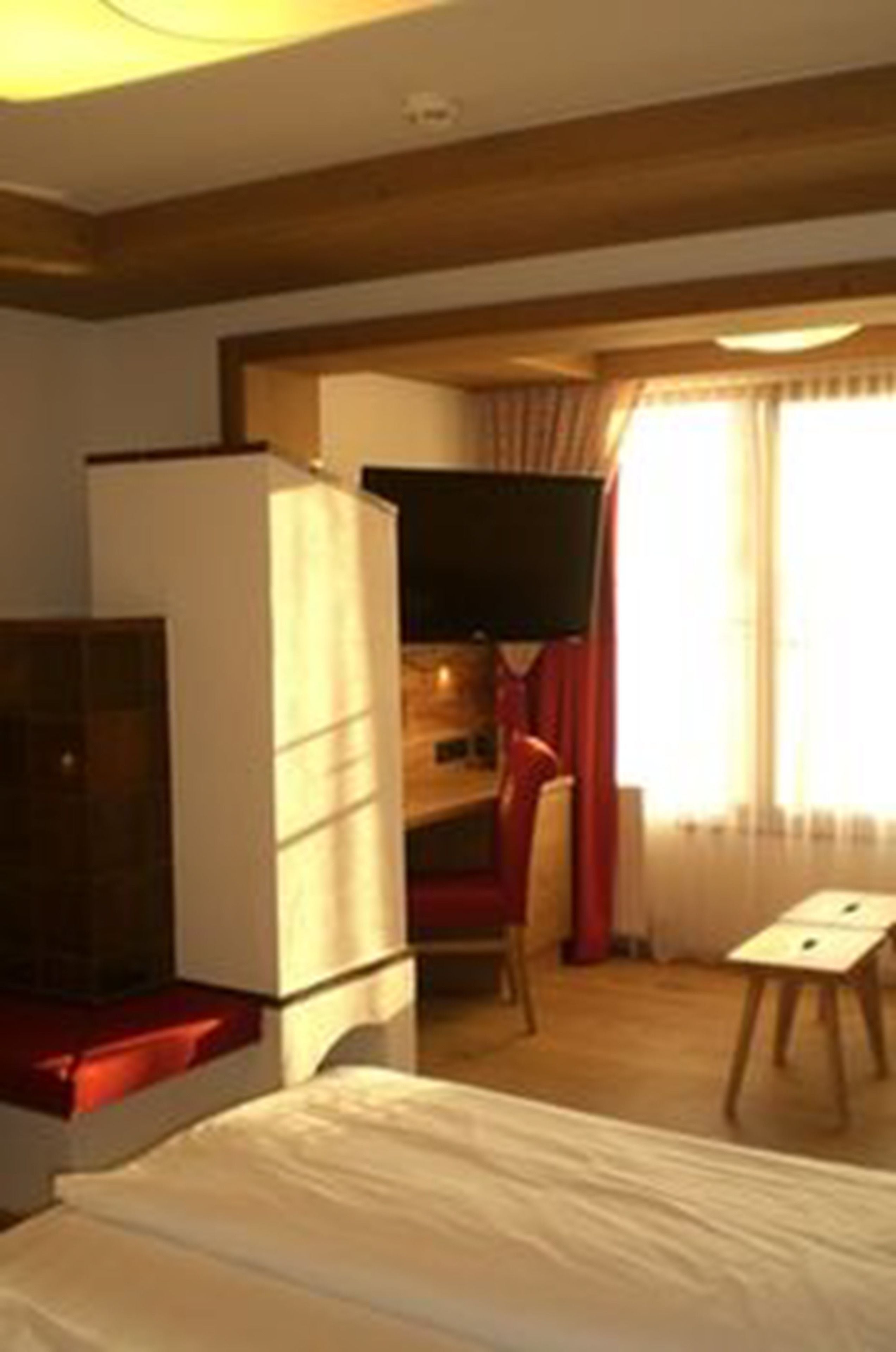 A hotel room with a bed, a television, a desk, and a chair.