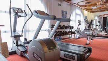 A gym with treadmills, elliptical machines, and free weights.