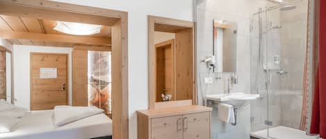 Un baño moderno con ducha, lavamanos y muebles de madera.