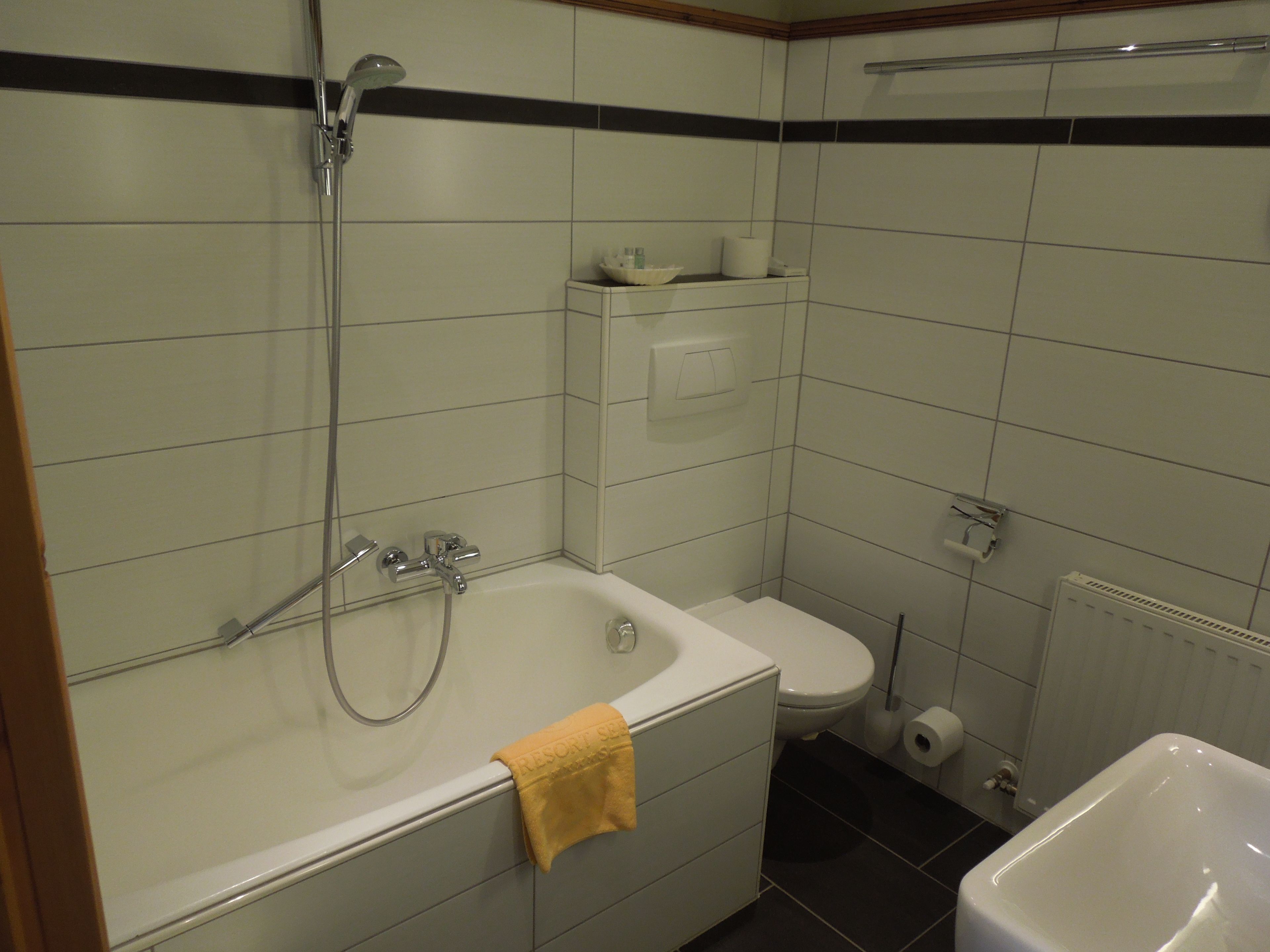 Un baño con bañera, inodoro y ducha.