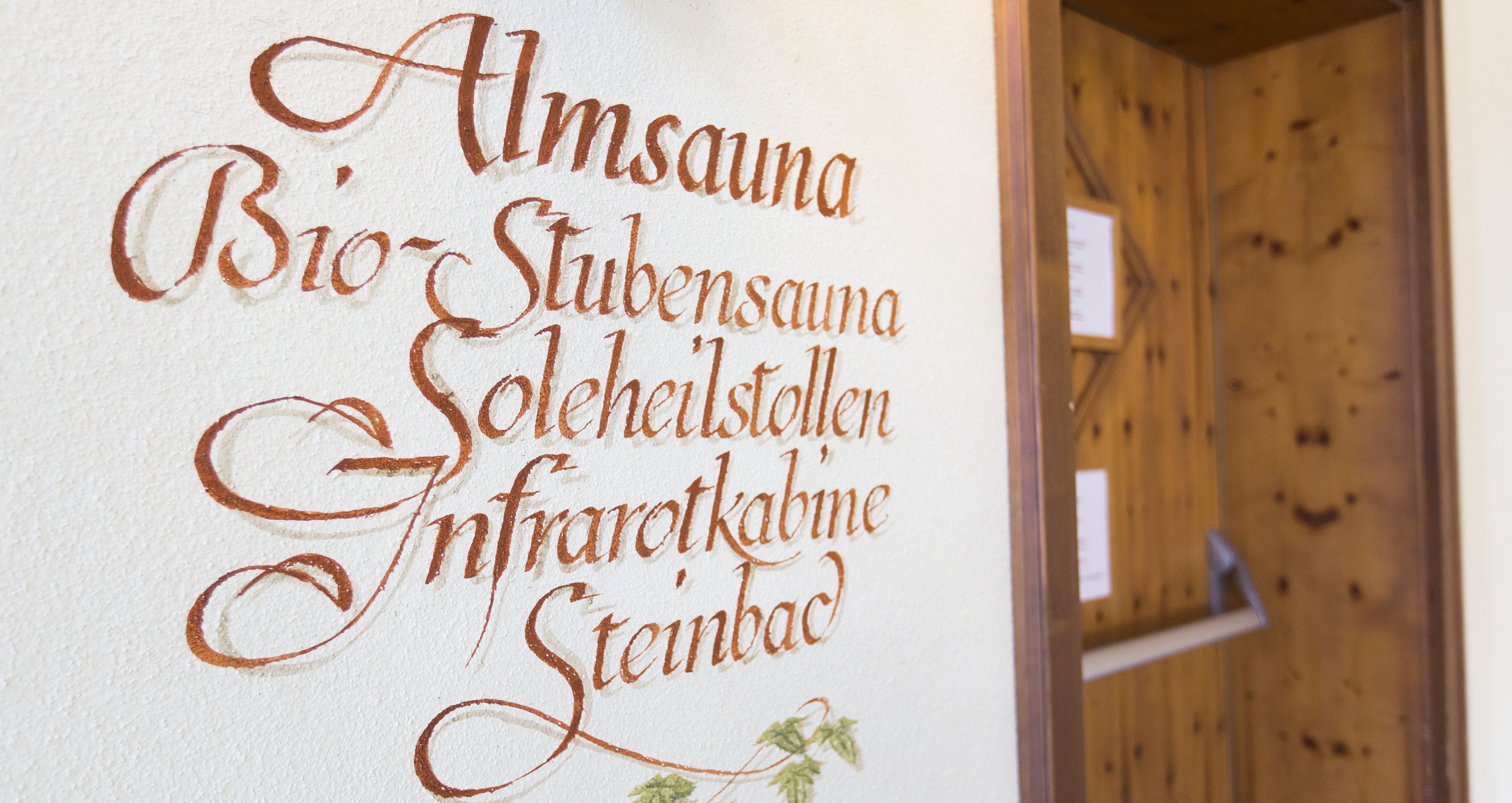 A wall with text in a foreign language, likely indicating a hotel or accommodation name.