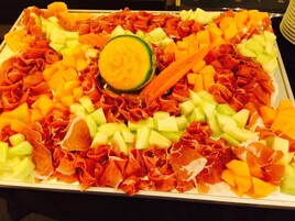 A platter of assorted meats and fruits.