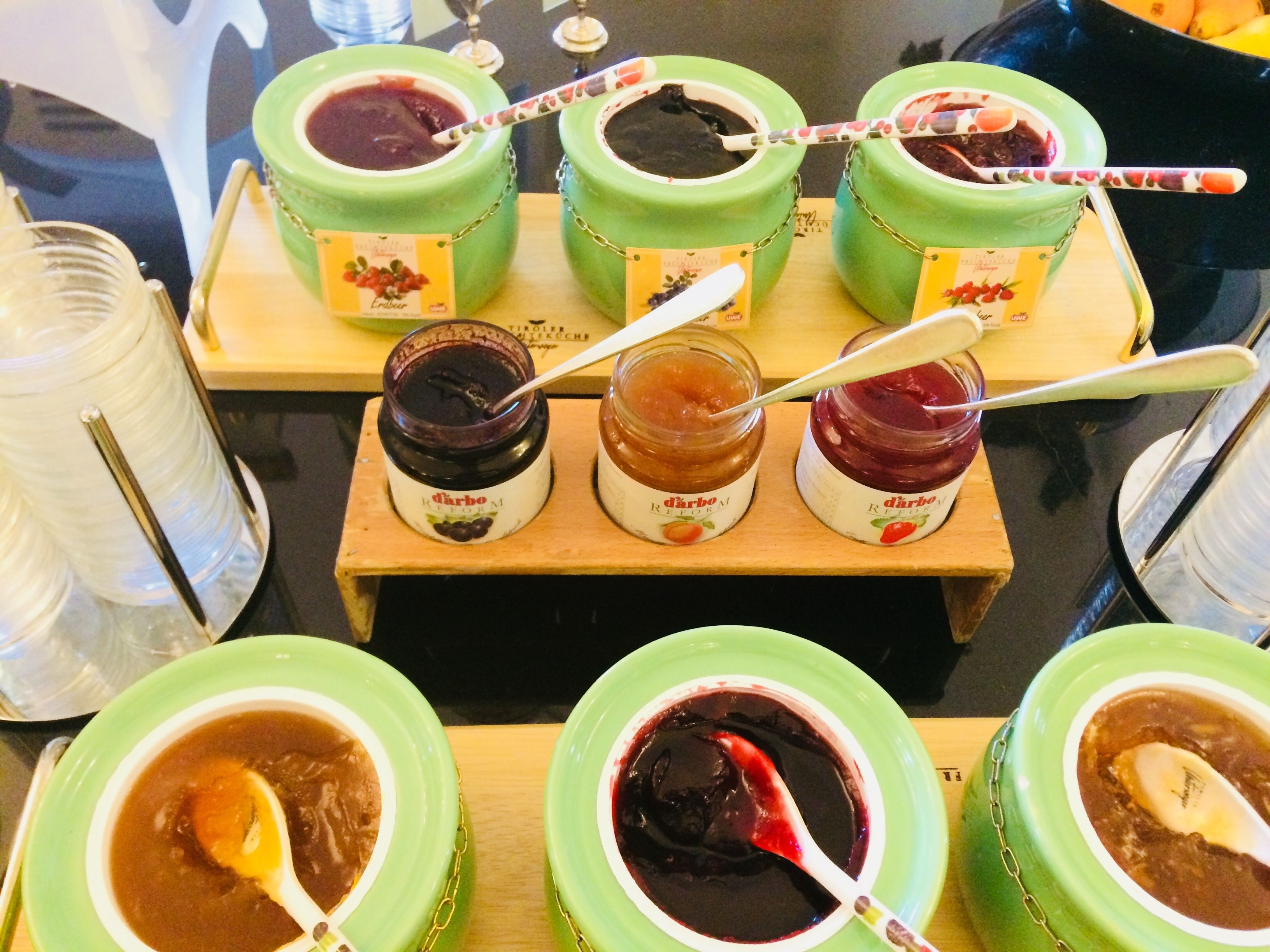 Una exhibición de frascos con distintos tipos de pastas y untables, cada uno etiquetado con un nombre y un sabor.