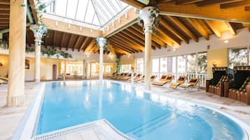 Una piscina al aire libre, sombrillas, sillones reclinables de piscina