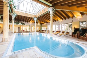 Una piscina al aire libre, sombrillas, sillones reclinables de piscina