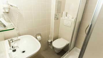 A bathroom with a sink, toilet, and shower area.