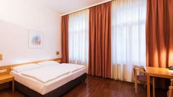 Ein Hotelzimmer mit einem Bett, einem Schreibtisch und einem Stuhl.