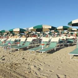 Trên bãi biển, ghế dài tắm nắng, dù trên bãi biển, khăn tắm biển