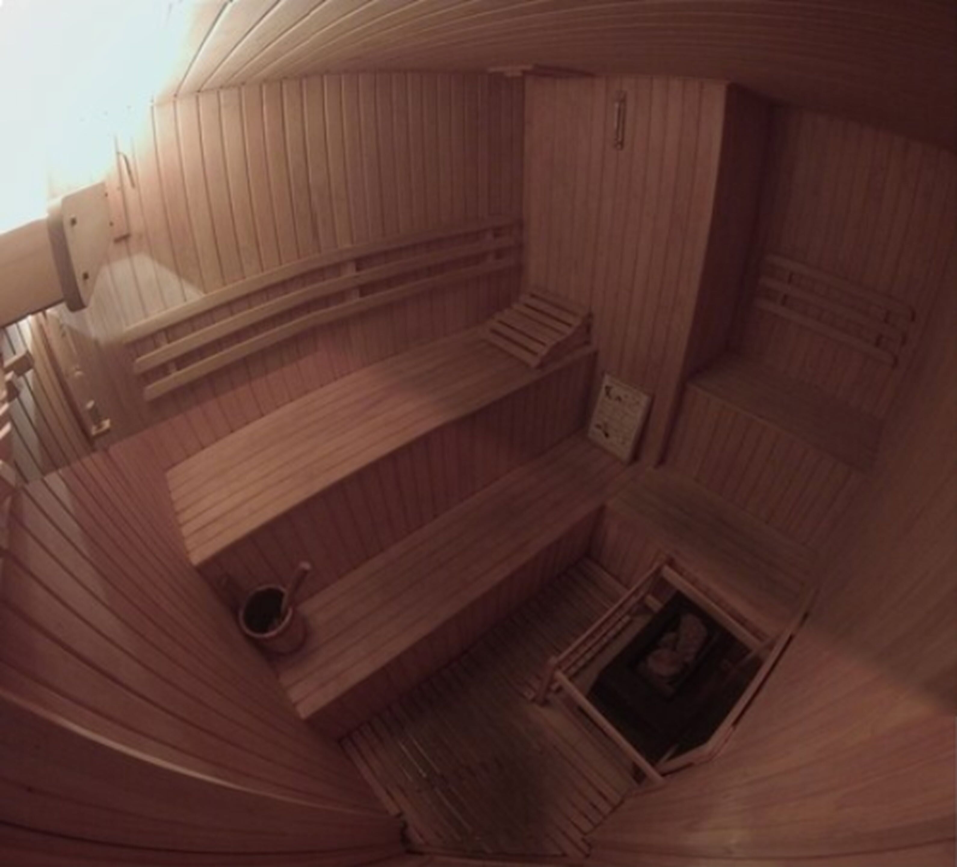Un sauna avec des murs et des bancs en bois.