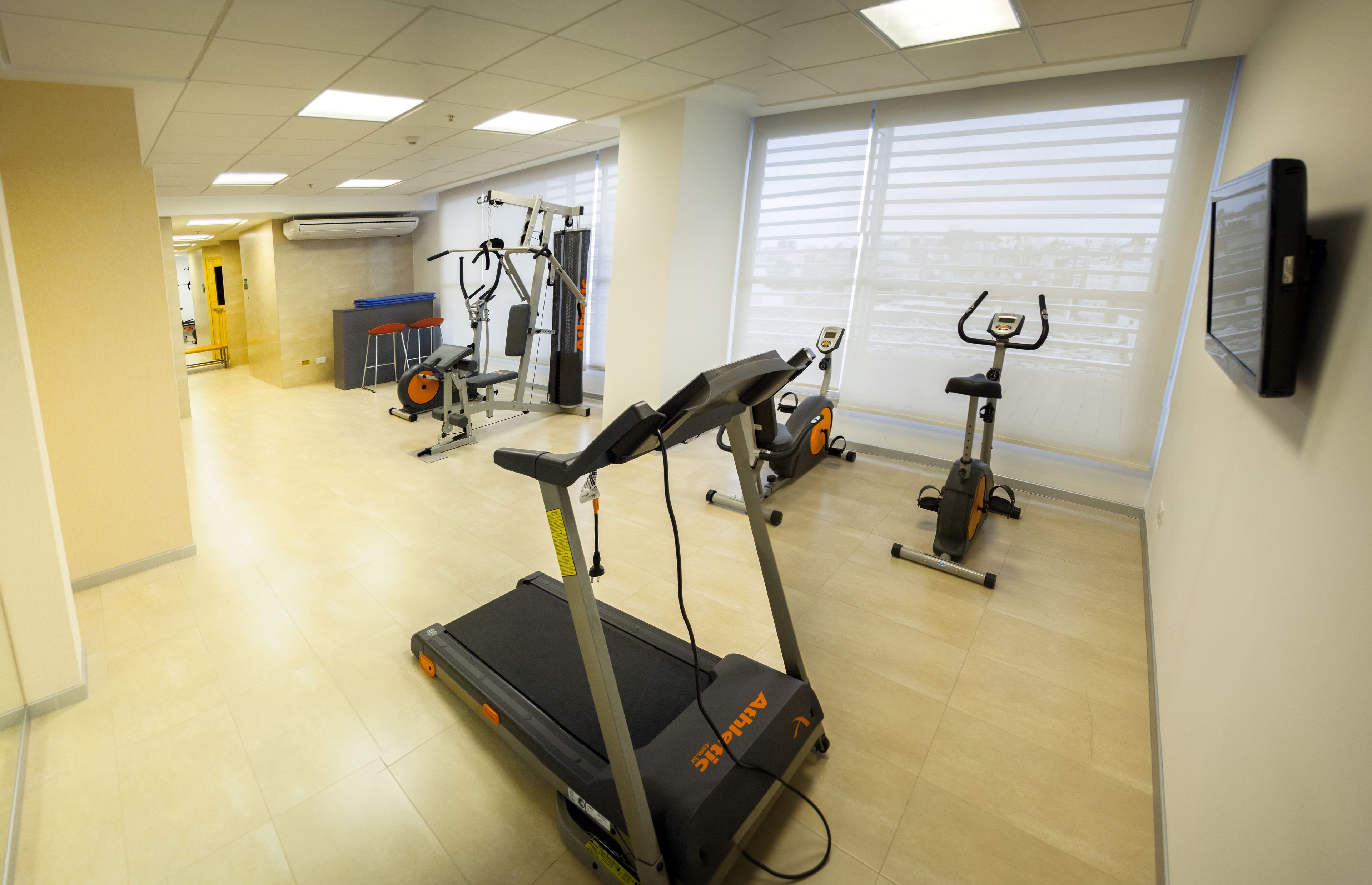 Un centre de remise en forme équipé de tapis de course, de vélos d’appartement et d’appareils de musculation.