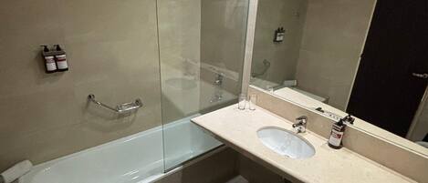 Un baño moderno con ducha de vidrio, bañera, lavabo e inodoro.