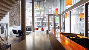 A modern interior with a staircase, seating area, and large windows.