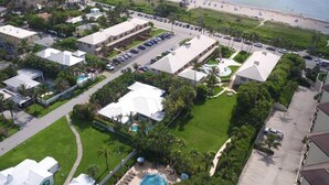 An aerial view of a resort with multiple buildings, a parking lot, and a swimming pool. - Getaways At Dover House (Delray Beach)