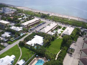 Vista aerea di un resort con diversi edifici, un parcheggio e una piscina.