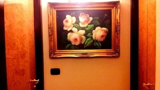 Uma porta com um quadro emoldurado de flores.