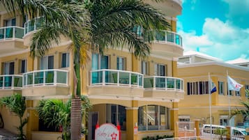 A multi-story hotel with balconies, palm trees, and a sign for Baker's Suites.