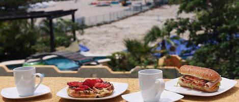A balcony with a view of a beach and hotel buildings.
