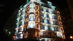 A multi-story hotel with illuminated balconies and a classic architectural design. - Albert Premier (Algiers)