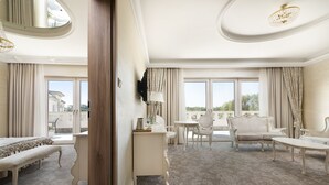 A spacious room with a large window, a sofa, a table, and a bench. - Hotel Kiston (Suleczyno)