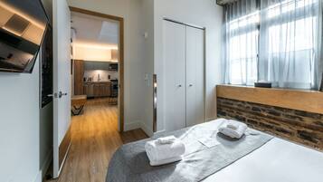 Una habitación de hotel con cama, baño, zona de cocina y vistas al exterior.