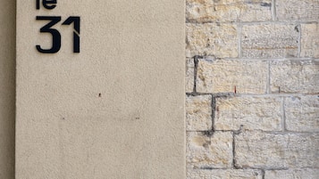 A wall with a beige textured surface and a stone wall section. The number "31" is visible on the beige surface.